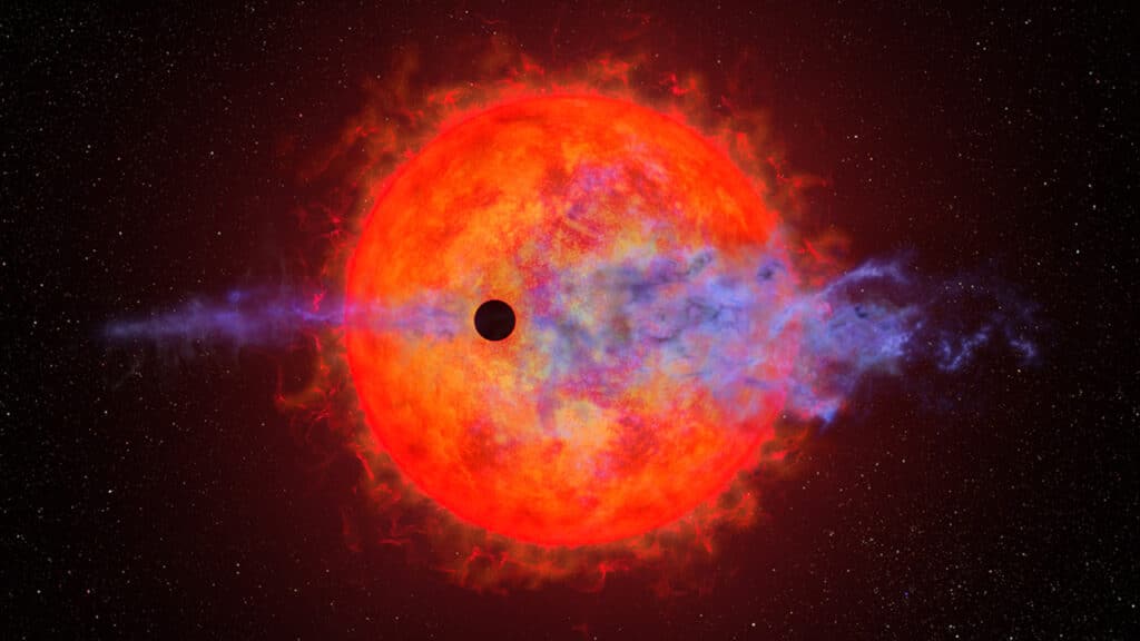 This artist's illustration shows a planet (dark silhouette) passing in front of the red dwarf star AU Microscopii.
