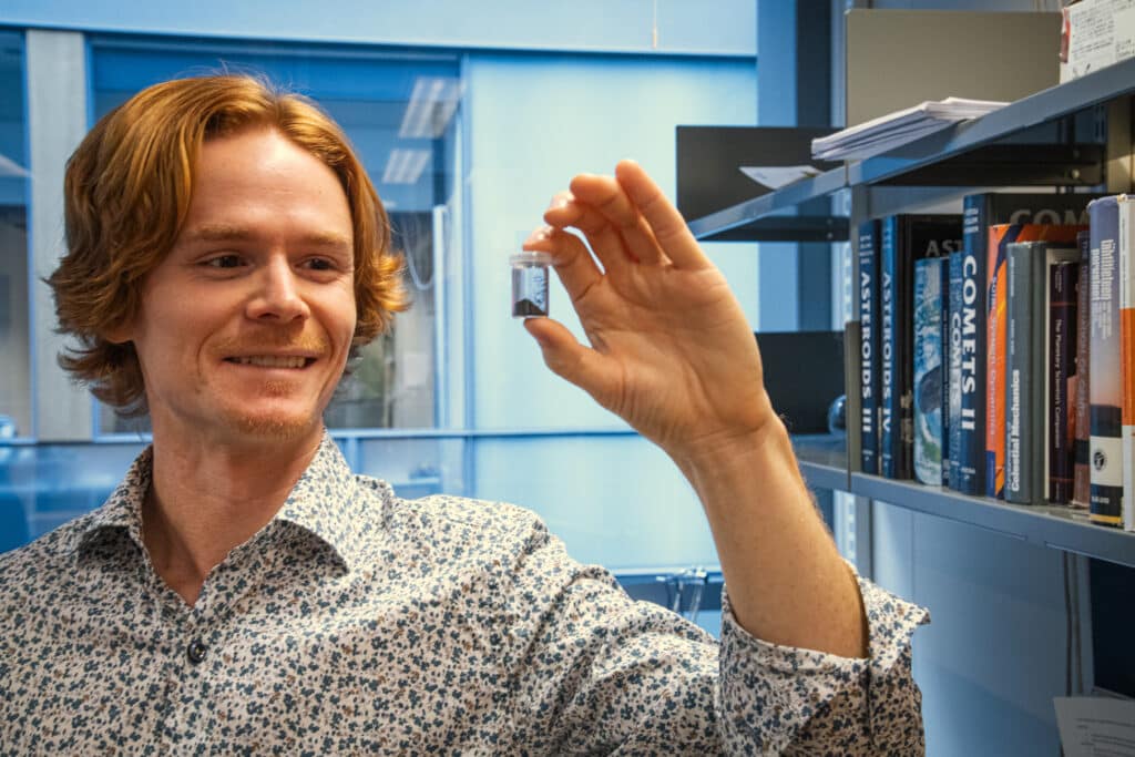 Postdoctoral Researcher Eric MacLennan holds in his hands a very rare type of meteorite, the so-called CY carbonaceous chondrite. Only six specimens of the same type are known. The sample is on loan from the Natural History Museum in London.